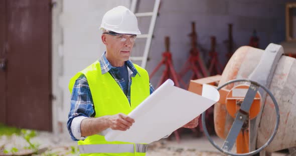 Confident Mature Male Engineer Analyzing Blueprint