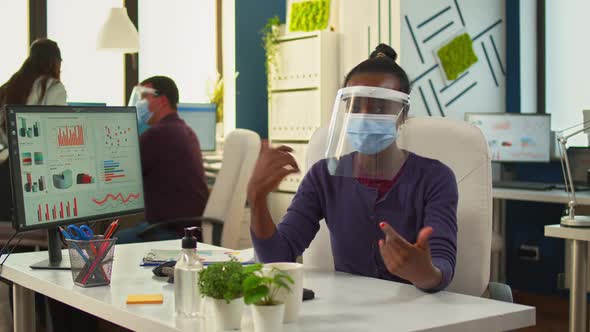 African Businesswoman with Visor Talking at Camera