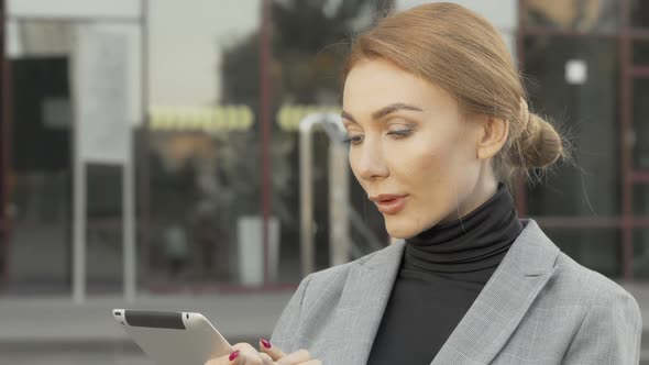 Attractive Businesswoman Using Digital Tablet Outdoors