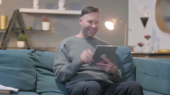 Casual Man Talking on Video Call on Tablet on Sofa