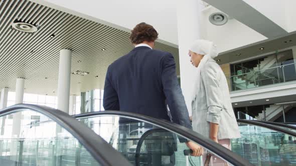 Young business people on an escalator in a modern building