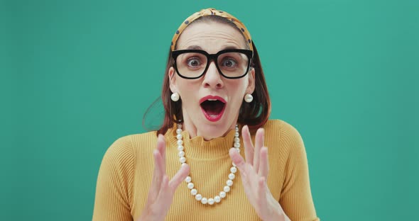 Woman looking at the camera looks surprised and starts clapping her hands. Isolated.