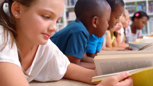 School kids reading book in library