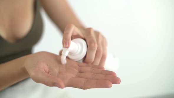 Squeezing Out Foam for Washing Into the Palm of a Woman's Hand