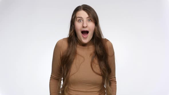 Studio Shot of Cheerful Amazed Woman Opening Mouth and Showing Oh My God Expression