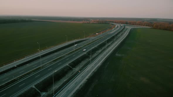 Aerial Shot of a Trucks and Cars on the Road Out of Town on the Highway on Sunset