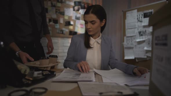 Detective Man Offering Coffee to Female Colleague, Working on Case Together