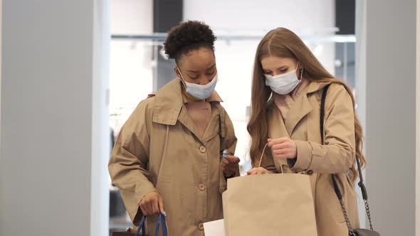 Beautiful Girls are Holding Shopping Bags and Shopping in the Mall