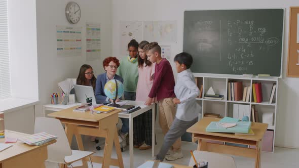 Geography Teacher Talking to Kids in Classroom