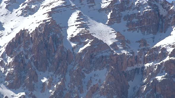 Rocky Snowy Mountain Summit Under Thermal Fluctuation of Hot Weather in Sunny Winter Day