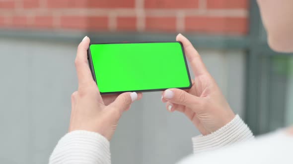 Outdoor Woman Looking at Green Smartphone Screen