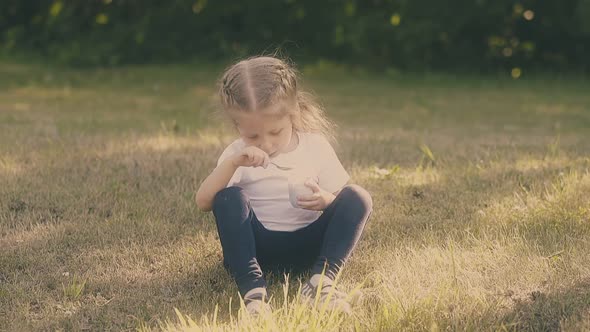 Girl with Braids Wearing White Tshirt Eats Tasty Dessert