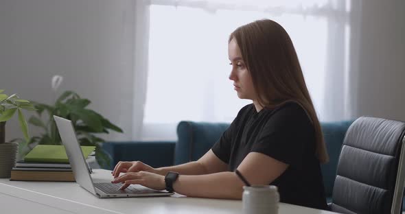 Female Office Worker Is Working From Home Typing and Sending Messages By Laptop Translator 