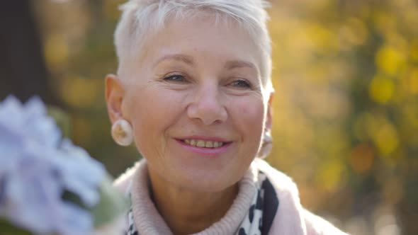 Portrait of Beautiful Aged Woman Sitting Outdoors and Talking To Man on Date