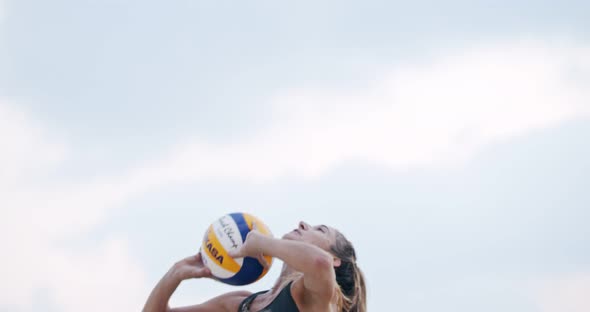 Slow motion of women playing beach volleyball during sunset