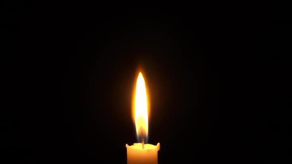 Woman Puts Out the Flame of a Yellow Candle with Her Fingers