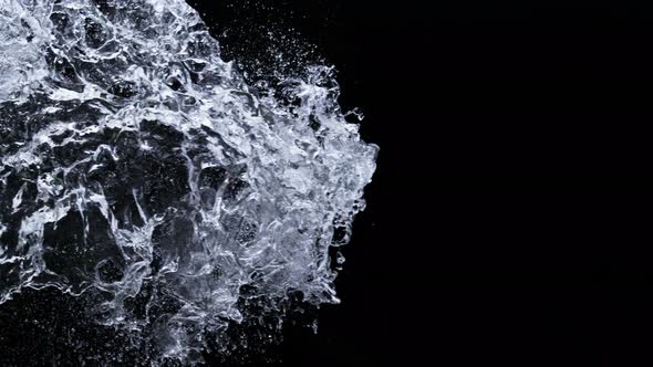 Super Slow Motion Shot of Side Water Splash Isolated on Black Background at 1000Fps alt