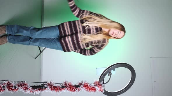 A Girl with White Hair Shoots a Video for Social Media Using Her Phone and Light