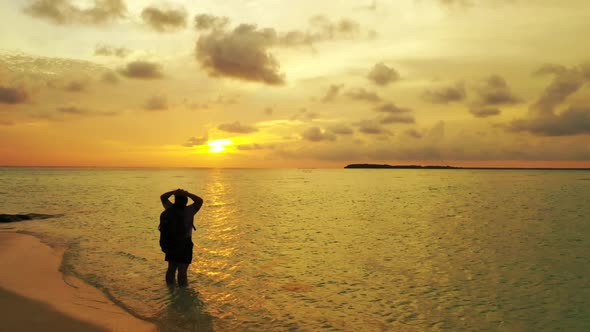 Lady alone sunbathes on idyllic resort beach voyage by blue ocean and white sandy background of the 