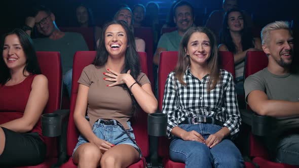 Two Female Friends Laughing Having Positive Emotion at Comedian Movie Sitting on Armchair Row