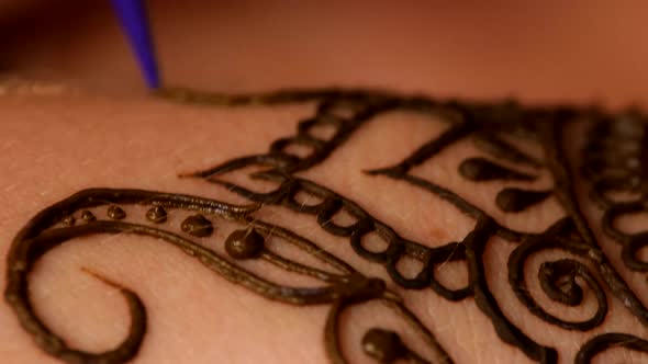 Womans Hand Being Decorated with Henna Tattoo, Mehendi, on White, Close Up, Cam Moves Upwards