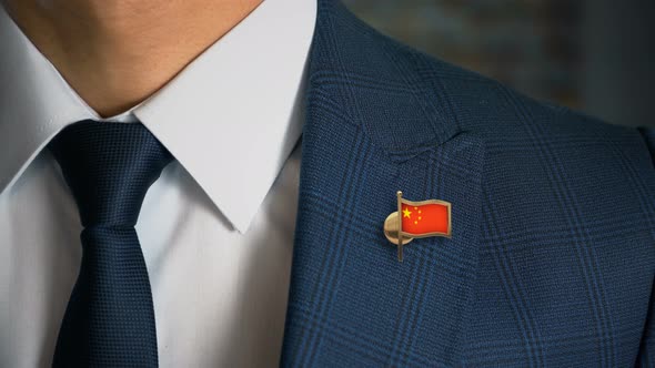 Businessman Walking Towards Camera With Country Flag Pin China