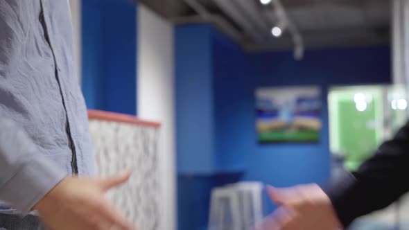 Closeup Handshake of Two Young Caucasian Men in Office Corridor