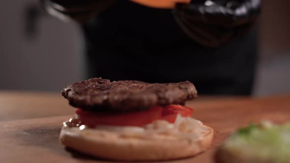 a Stepbystep Process of Making a Burger the Chef Lays Down the Meat and Cutlet and Covers the