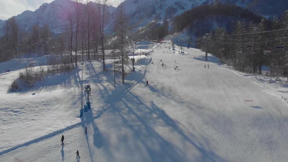 From the Air the Drone Takes Pictures of People Skiing Down the Mountain in Winter As Well As Trees