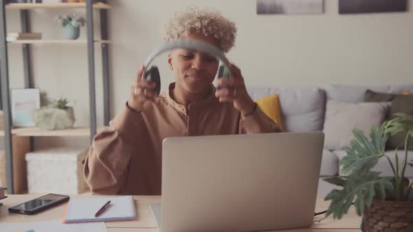 Afro Woman Puts on Headphones Start Online Call Via Laptop with Friend Student