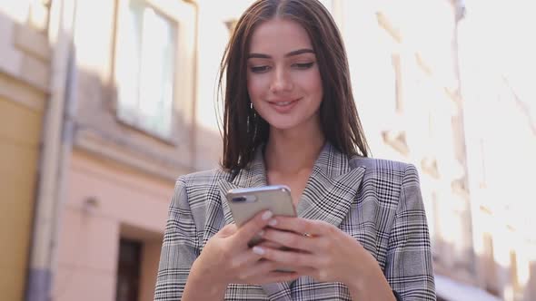 Beautiful Woman Using Mobile Phone On Street