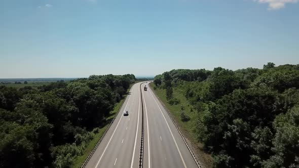  Aerial Shot of a Highway Passing Through the Rural Countryside and Green Forest