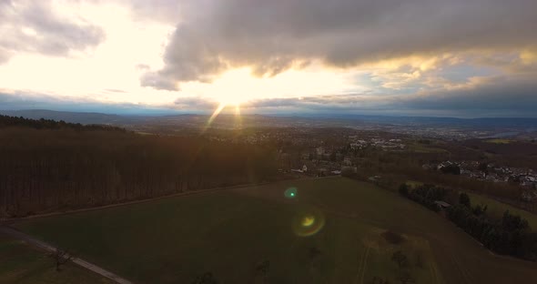 Drone decend over hill at sunset.