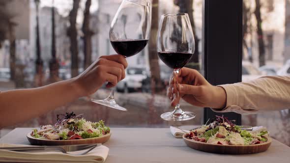 Close Up Shot of Couple in Love Clinking Wine Glasses During Romantic Date in Cafe Slow Motion