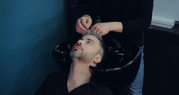 Man in a Barbershop Puts His Head in the Sink to Wash His Hair