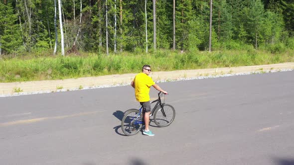 Aerial View From Drone on Man Riding on Asphalt Road