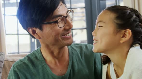 Daughter kissing father on cheeks in living room 