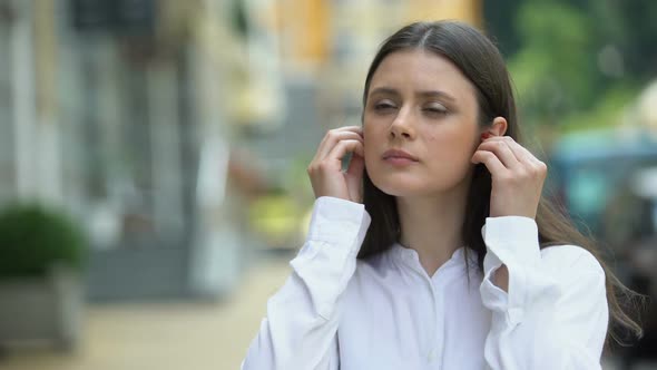 Woman Wearing Wireless Headphones on City Street