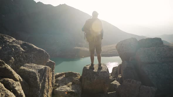 Hiker Tourist with Backpack Taking Photograph at Smartphone at Mountain Lake