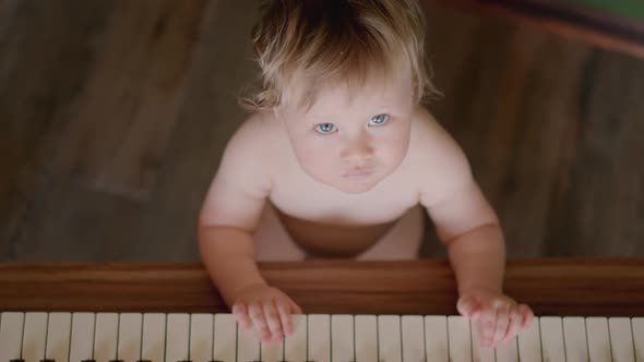 Asian Baby Girl Toddler Playing Electric Piano Sit Down on the Floor Tapping on Keyboard Music