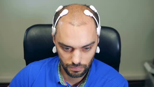 Man Wearing Robotic Brainwave Scanning Sensors on His Head, Close Up