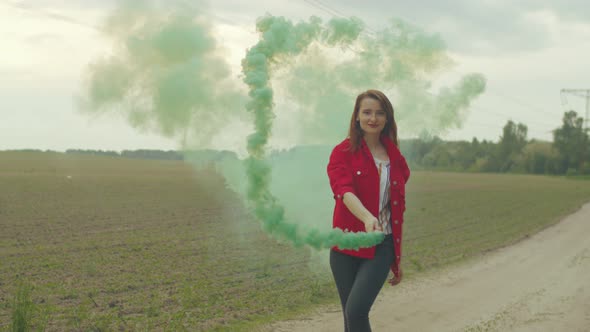 Woman Whirls in Color Smoke Walking on Rural Road