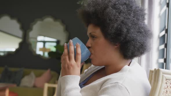 Video of relaxed plus size african american woman drinking coffee