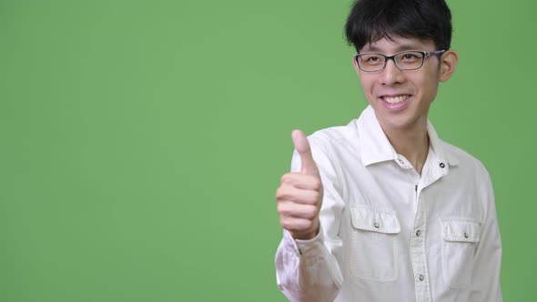 Young Asian Businessman Giving Thumbs Up