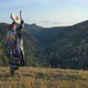 Siberian Shaman Performs a Ritual Dance and Beats a Tambourine on the Top of the Mountain. - VideoHive Item for Sale