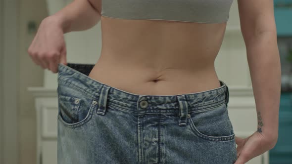 Close Up of Woman Wearing Oversized Jeans After Weight Loss