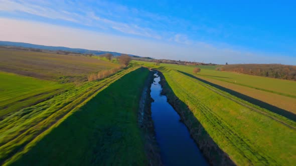 River through the large green Tuscan countryside. Acrobatic Aerial view