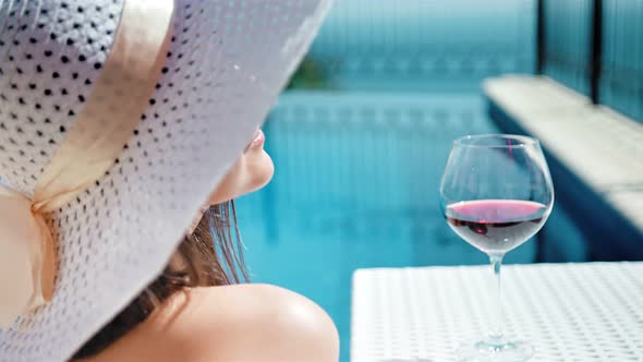 Portrait Smiling Pretty Woman in Floppy Hat and Sunglasses Enjoying Sunbathing with Goblet of Wine