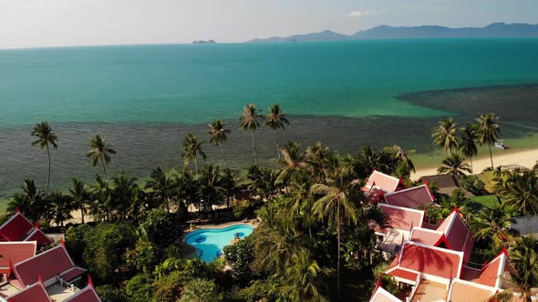 Oriental Houses on Seashore. Drone View of Lovely Oriental Cottages and Green Coconut Palms Located