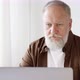 an elderly male businessman working on a laptop - VideoHive Item for Sale